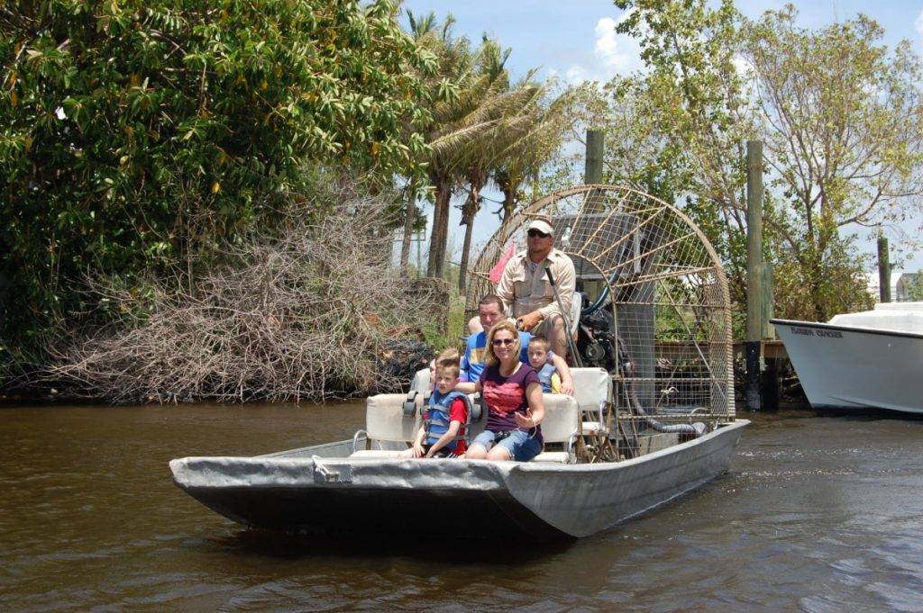 family of five on airboat with guide