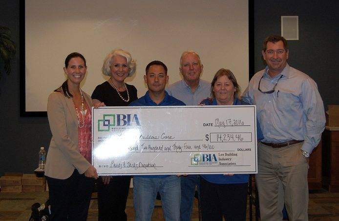 Lee BIA presents check to 5 Builders Care staff