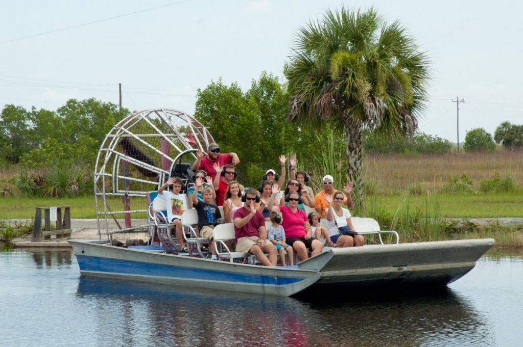 Air boat passengers wave as their boat leaves the dock