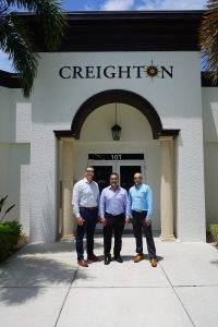 Charley Carpenter, Dan Creighton and Brent Evans stand in front of Creighton Construction & Development's Fort Myers office