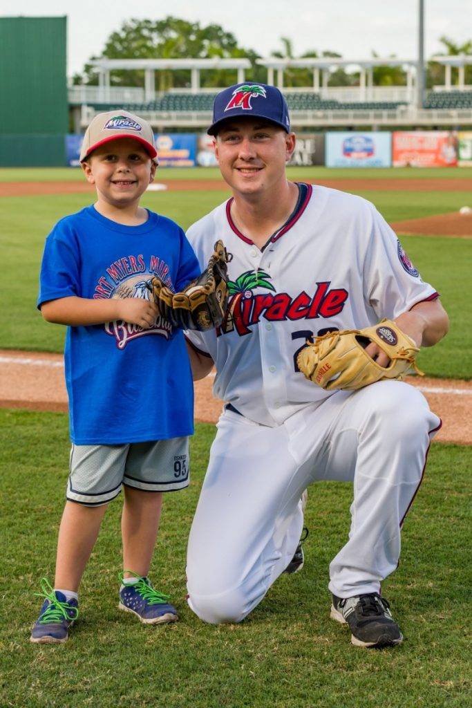 Fort Myers Miracle player with young fan in blue shirt