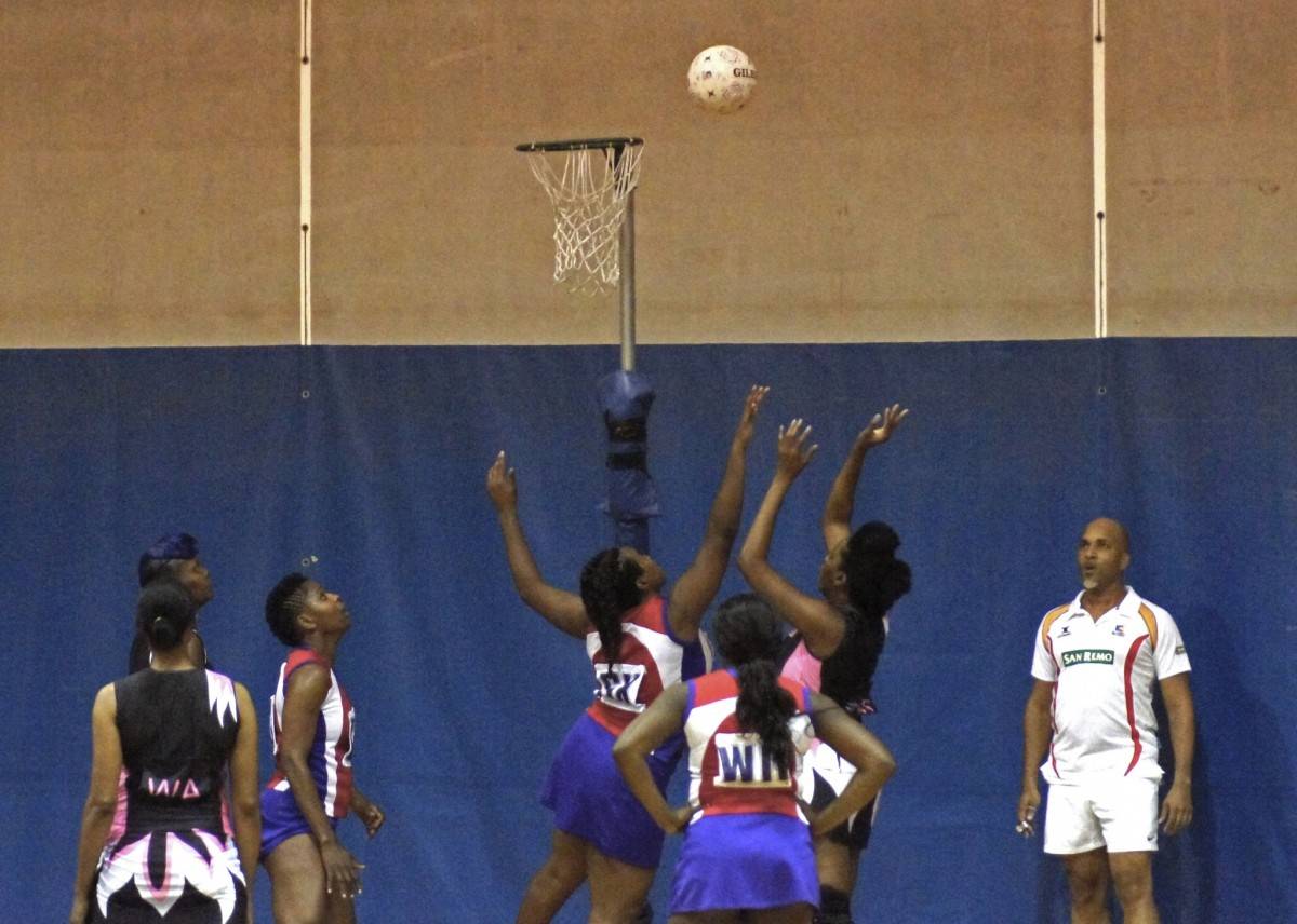 Team of 6 Black basketball female players jump in the air to catch basketball