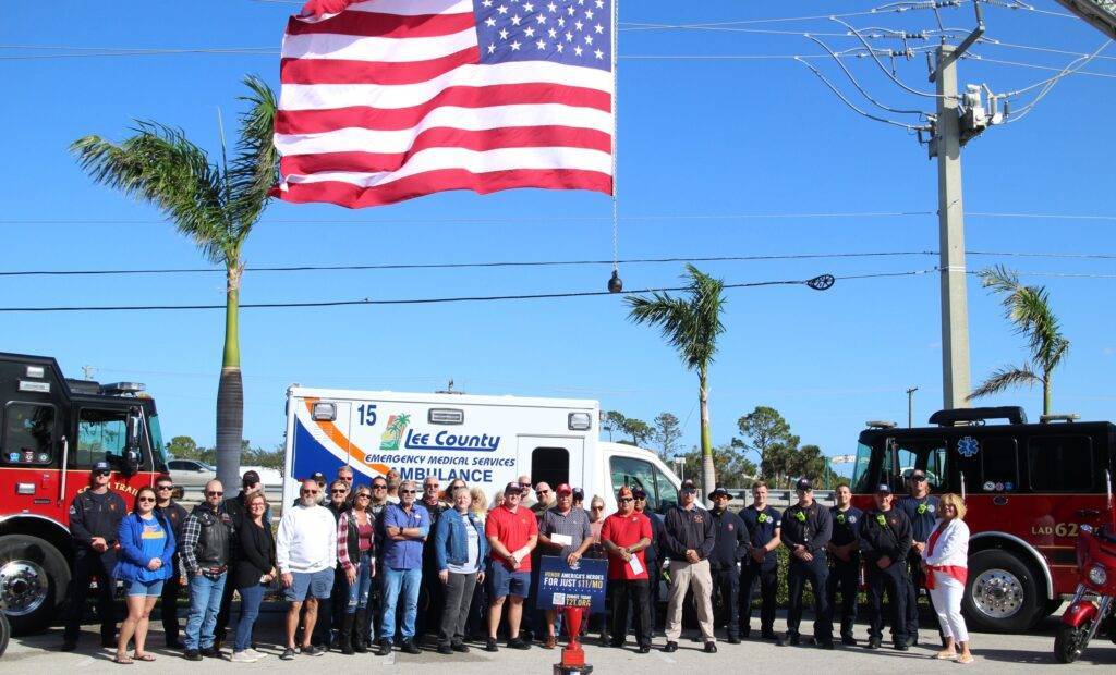 Lee County Fire and Rescue group in front of vehicles and flag during Lee County Chili Challenge special event