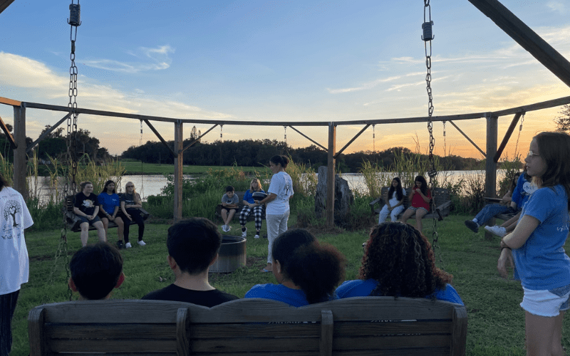Avow staff leading campers at Camp MendingHeart in reflective sunset meditation